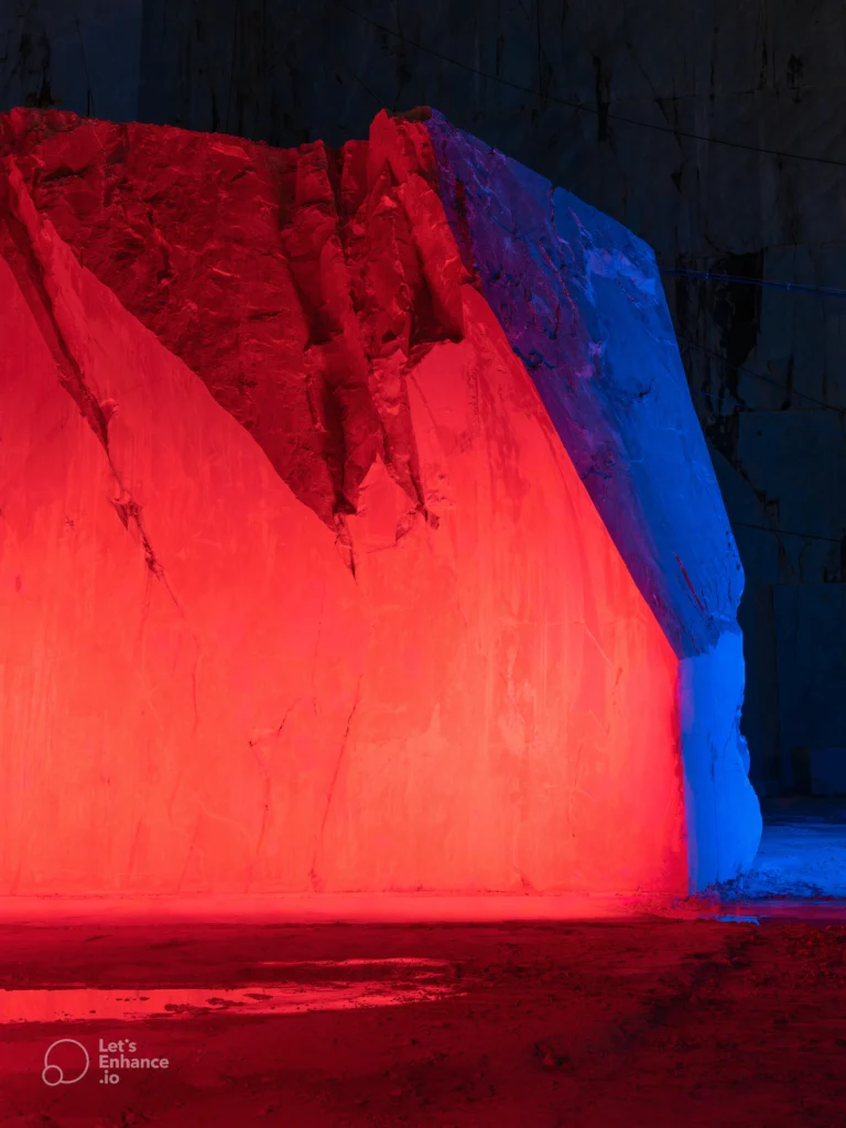 Dramatic blue-lit marble quarry interior with ladder showcasing the artistic beauty of raw marble extraction